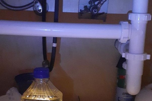 Cramped under-sink drain pipes before the repair