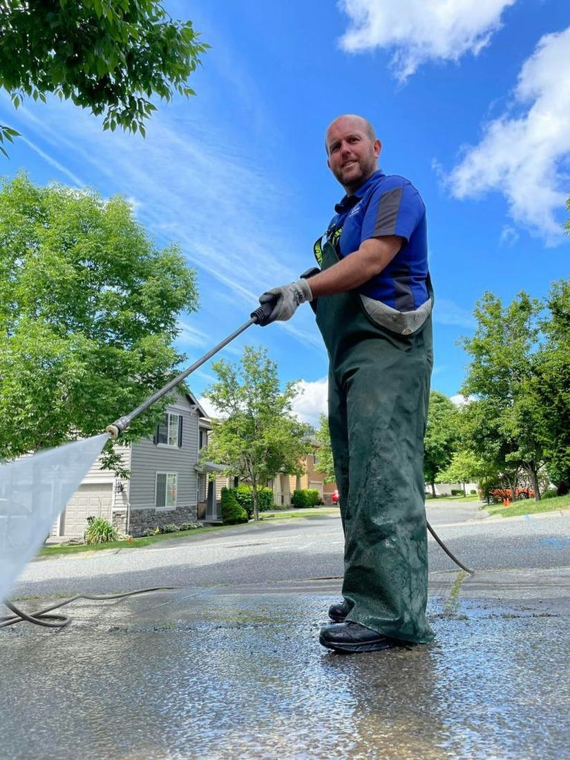 Technician pressure washing in a residential neighborhood