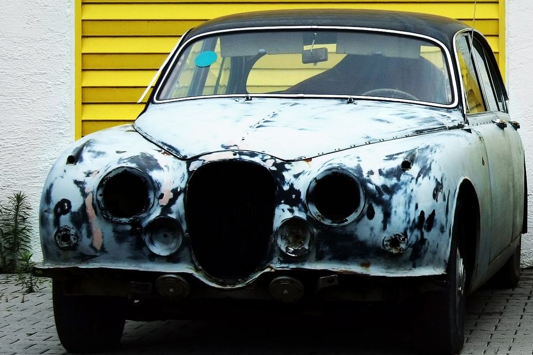 Classic sedan with bare, patched bodywork before paint
