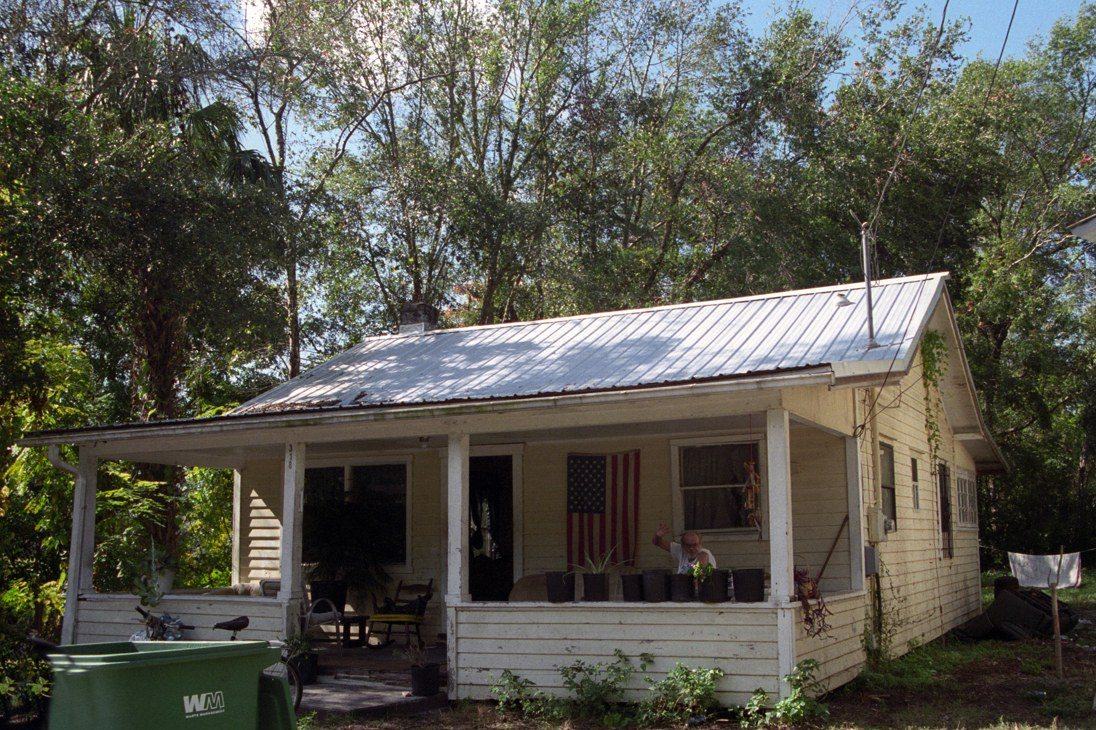 Faded cream cottage with a worn porch