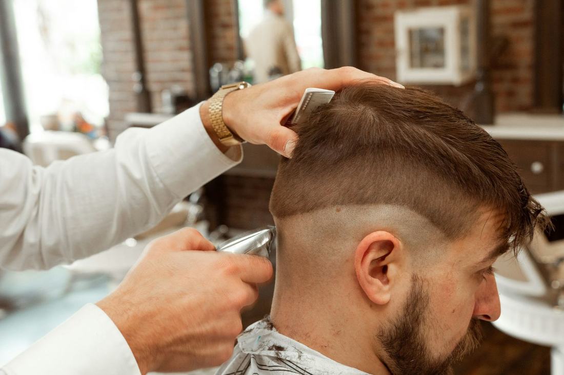 Barber shaping a fade haircut