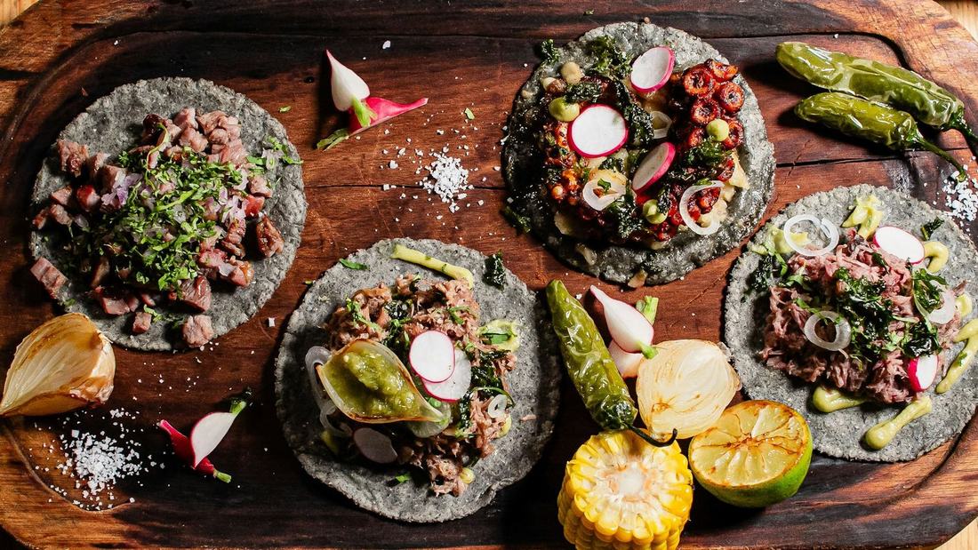 Tacos and grilled vegetables on a wooden table