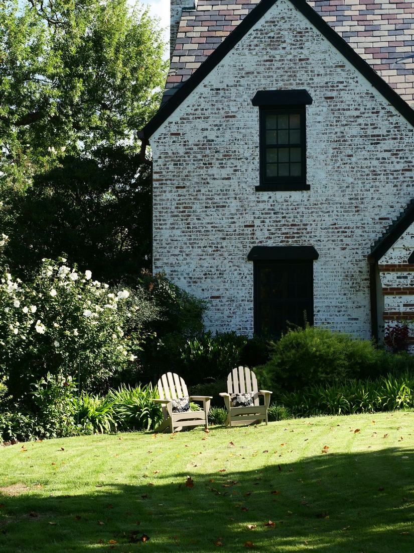 Flowering shrubs and patio seating by a home
